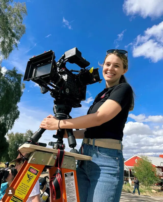 Selena operating a film camera on set